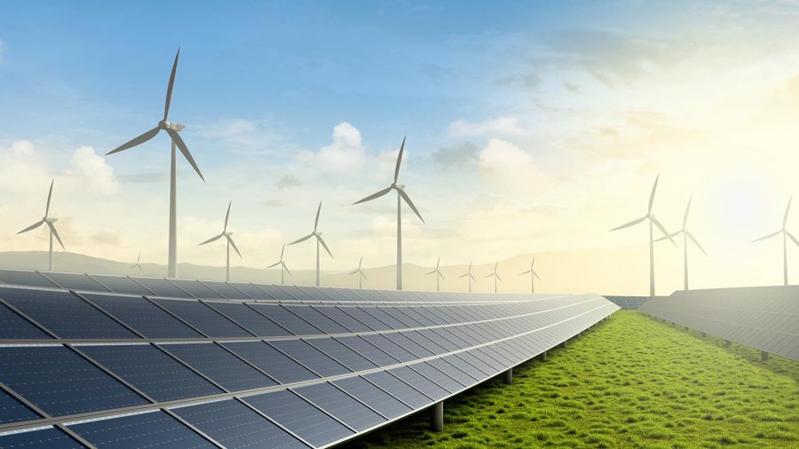 Solar farm and wind turbine on green fields with beautiful sunset background.